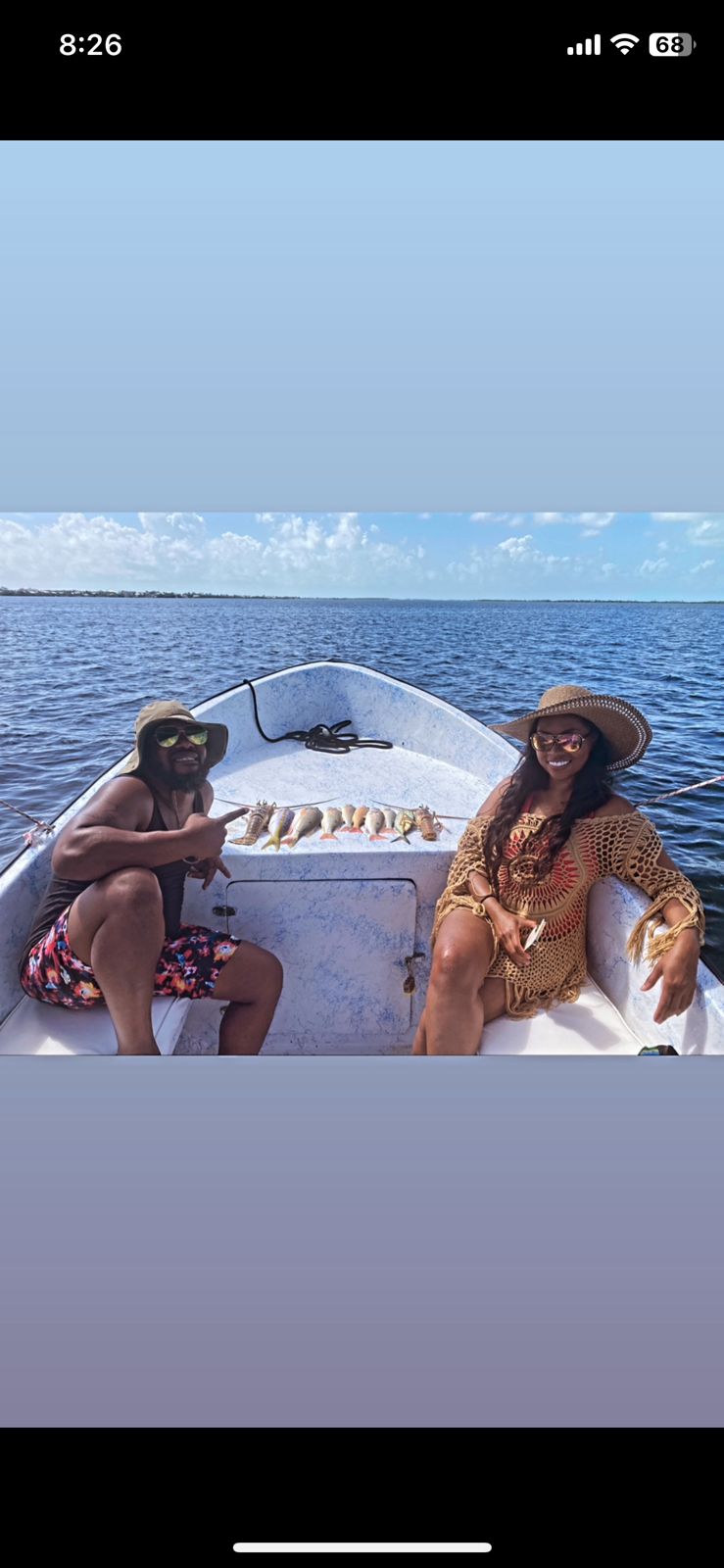 Couple relaxing in the bow of the boat beside a line of reef fish