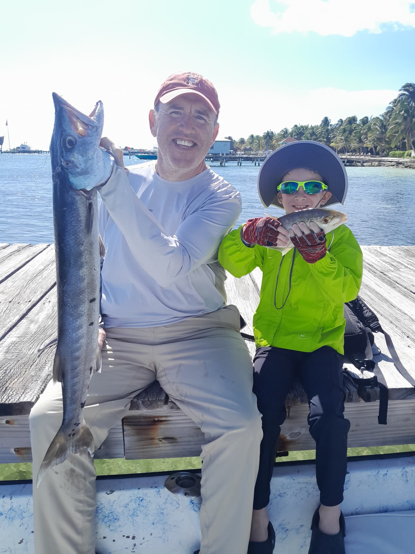 Father and son on the dock with a barracuda and a yellowtail snapper