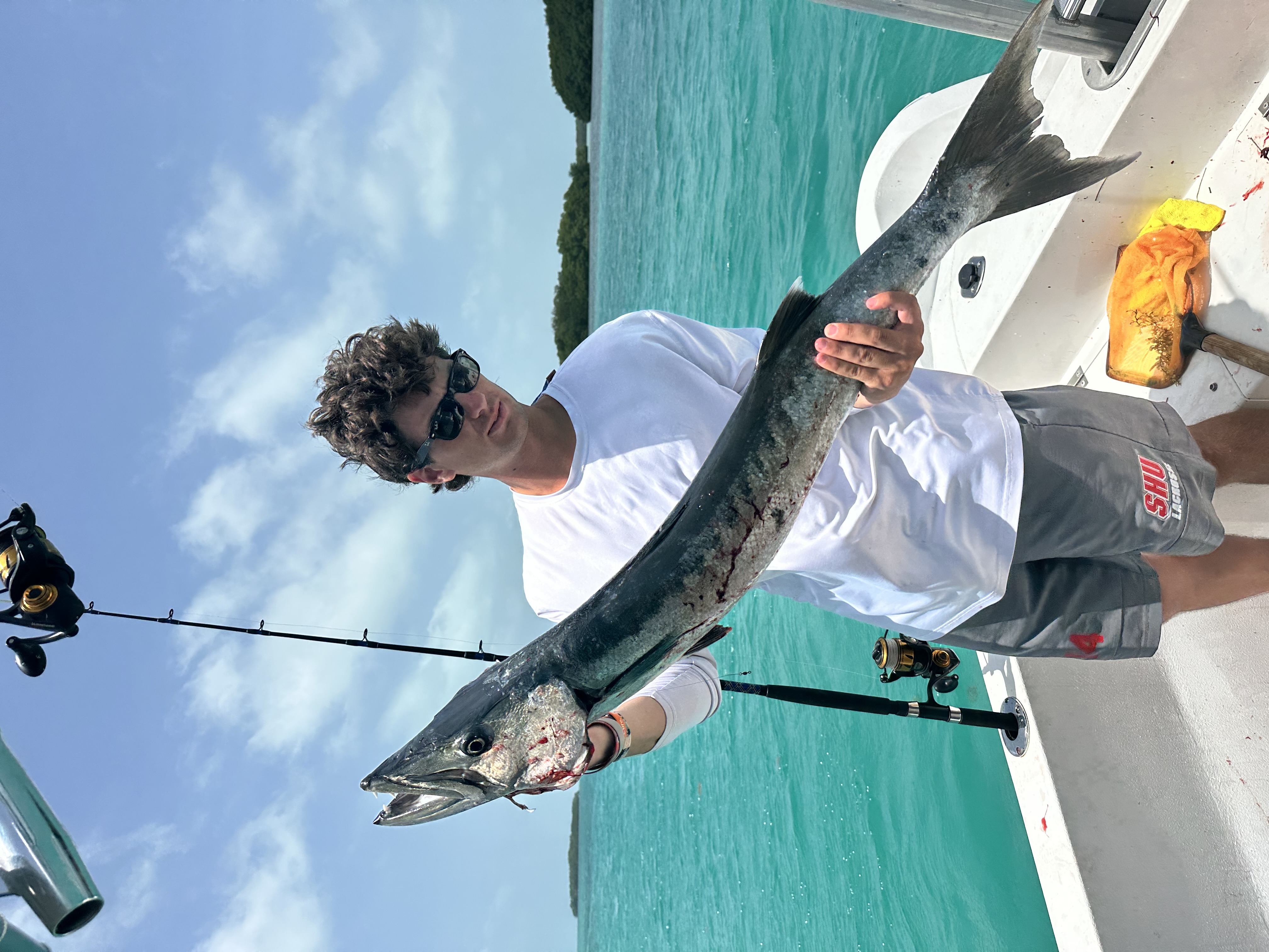 Guest showing off a barracuda caught over the Belize Barrier Reef