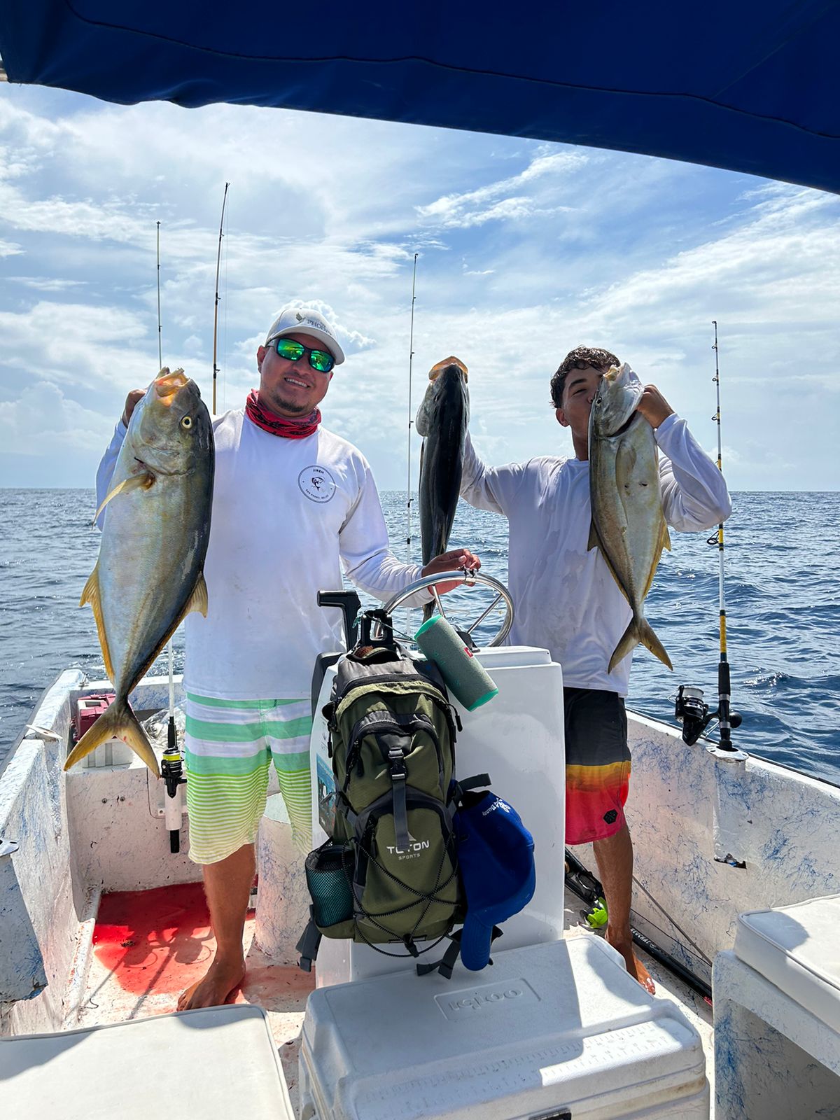 Captain and mate holding up big jack crevalle caught offshore
