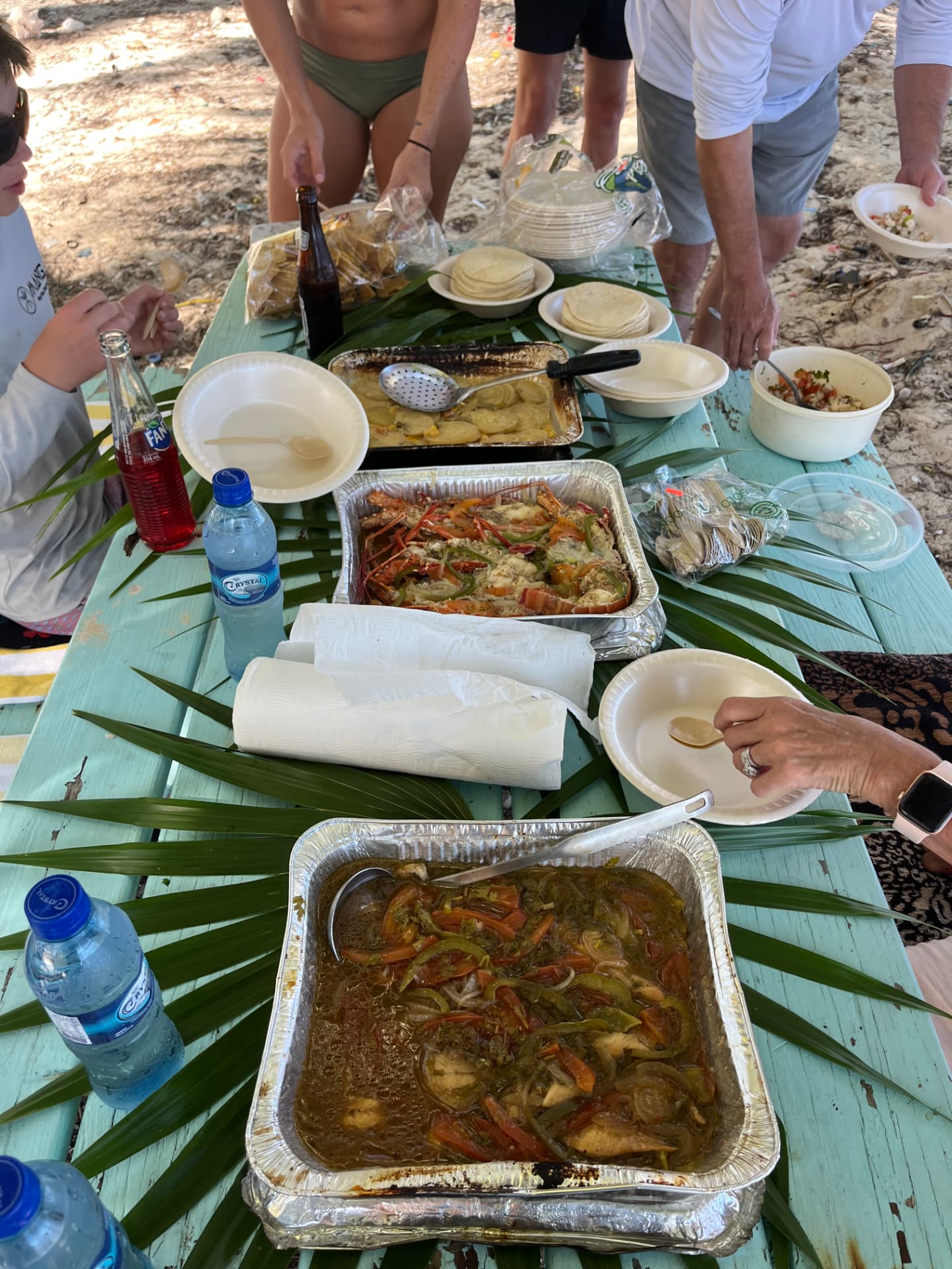 Fresh lobster, stew chicken and ceviche served on a beach picnic table