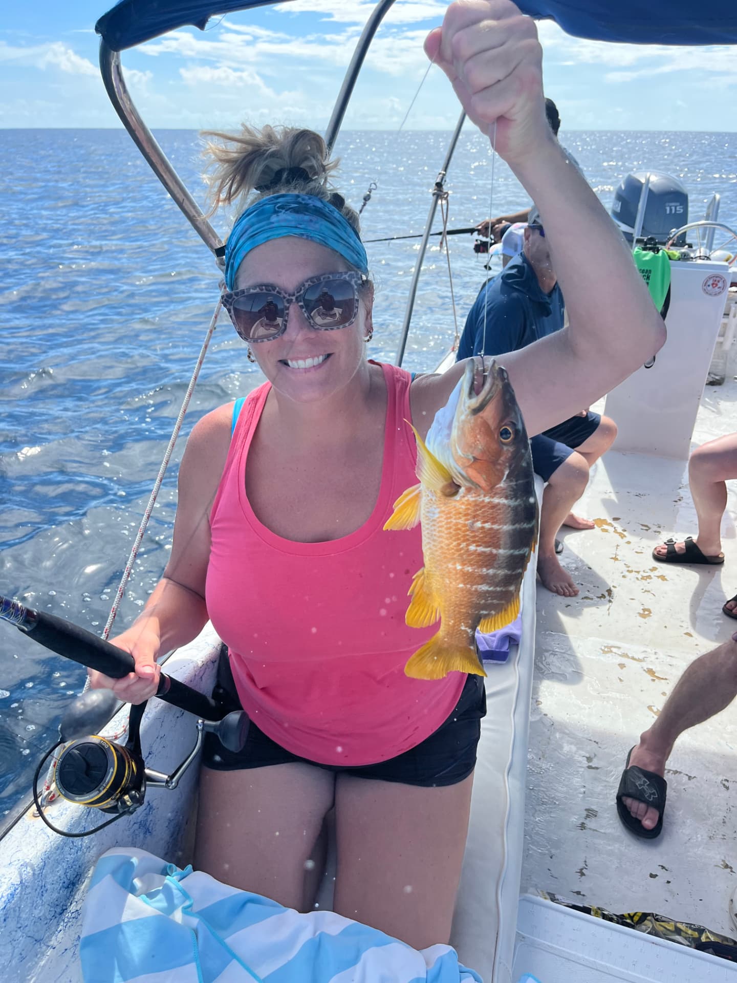 Guest smiling with a dog snapper caught on a reef fishing trip