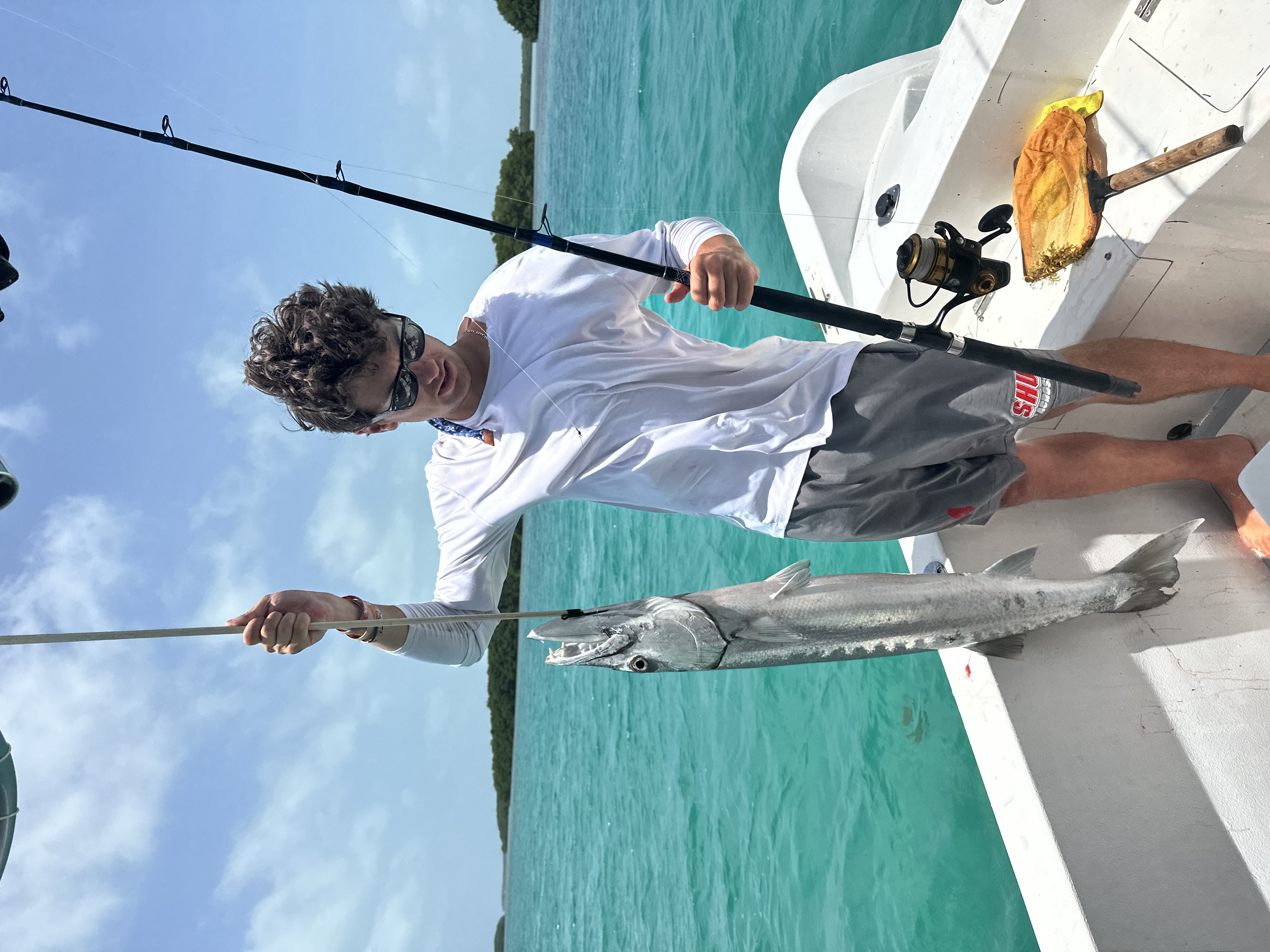 Guest holding a barracuda caught on the reef off Ambergris Caye
