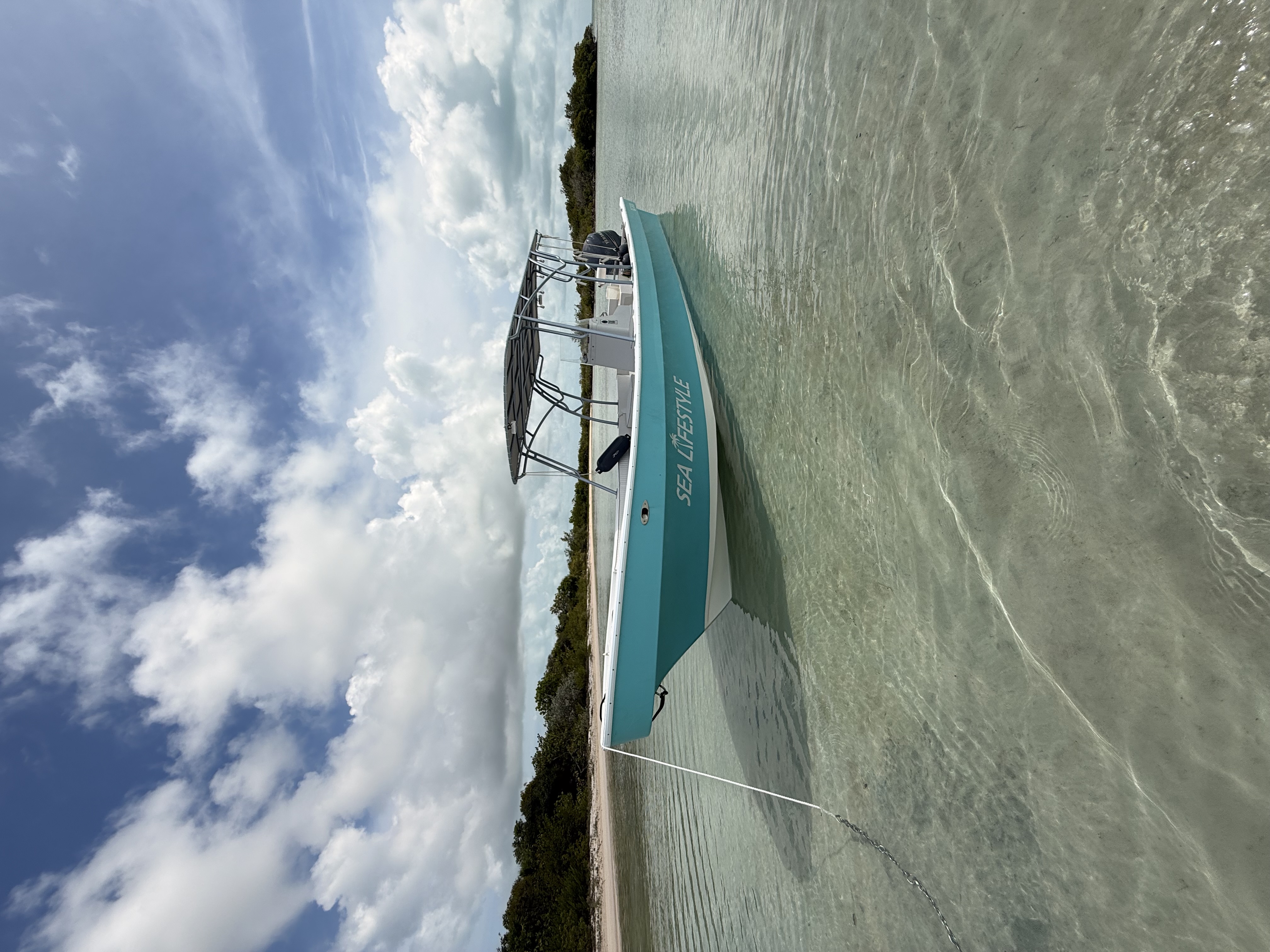 The Sea Lifestyle tour boat anchored in shallow turquoise water