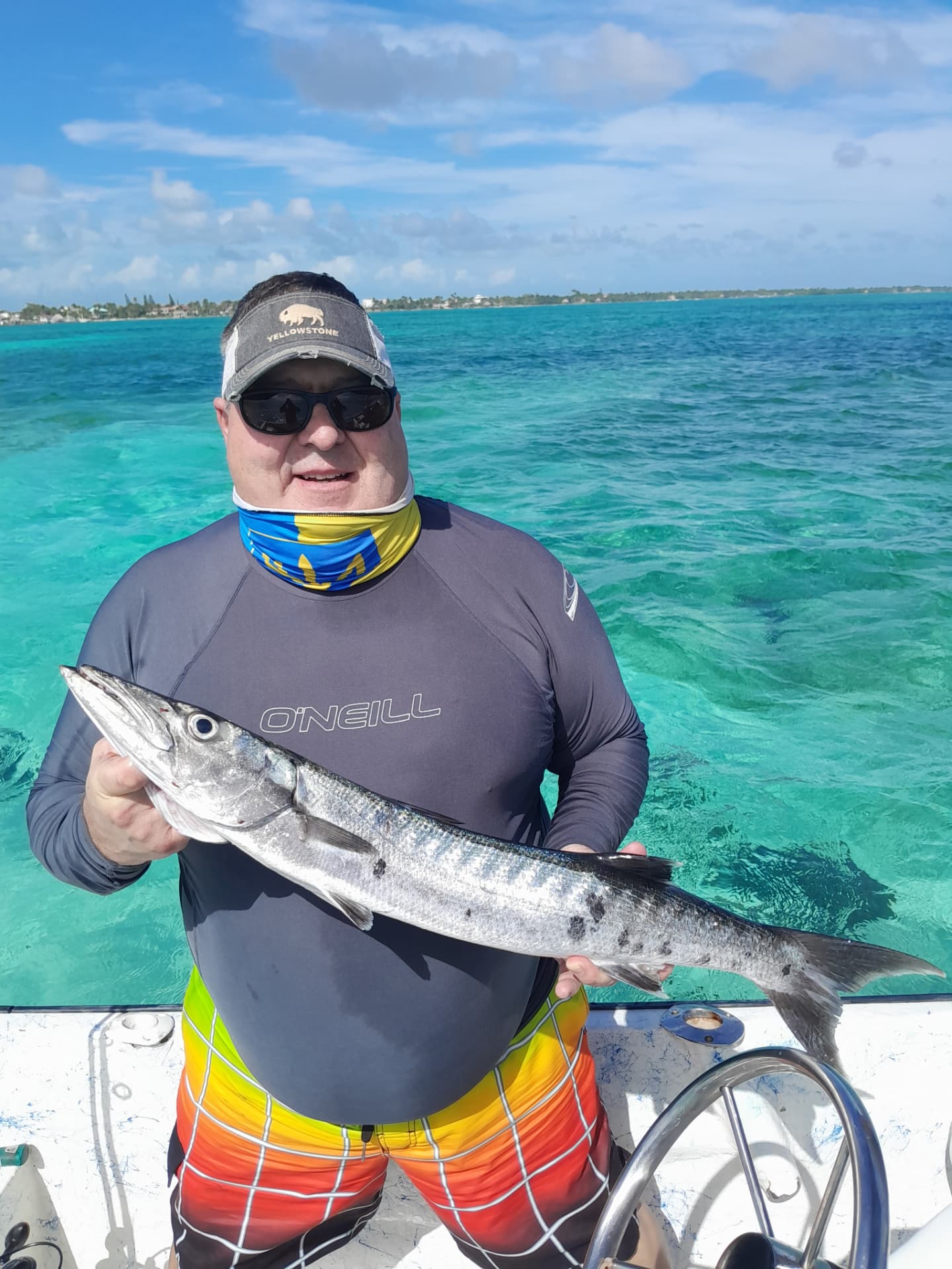 Guest holding a barracuda caught over the reef off Ambergris Caye