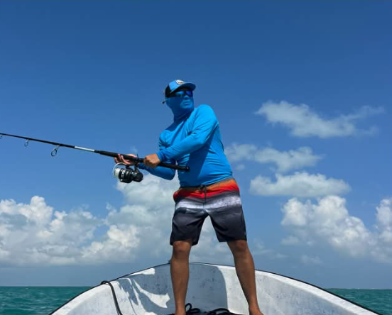 Angler casting a spinning rod from the bow of the boat